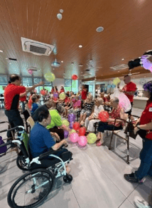 A group of people in a room with balloons
AI-generated content may be incorrect.