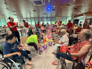 A group of people sitting in a room with balloons
AI-generated content may be incorrect.