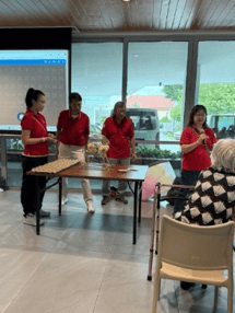 A group of people in red shirts standing in front of a table
AI-generated content may be incorrect.